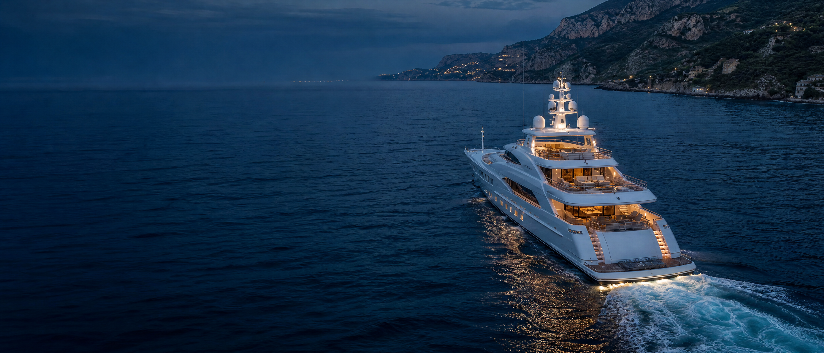 Superyacht cruising at dusk